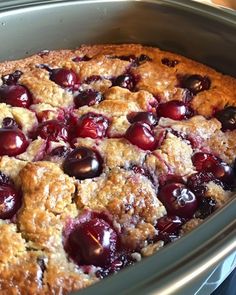 a close up of a pie in a pan with cherries on it and crumbs