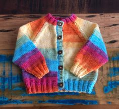 Handmade rainbow cardigan. Perfect layer for summer. Loose, light and super jolly! Wooden buttons.  Machine washable. Rainbow Cardigan Crochet, Playful Multicolor Sweater For Playtime, Fitted Multicolor Handmade Cardigan, Rainbow Knitted Cardigan, Rainbow Patchwork Cardigan, Pastel Rainbow Cardigan, Knitted Rainbow, Rainbow Cardigan, Kids Jumpers