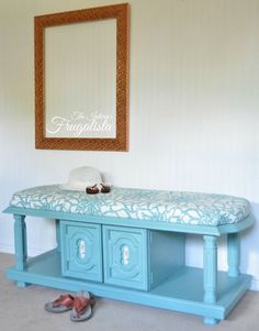 a blue bench with shoes on it in front of a mirror and a framed picture