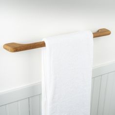 a white towel hanging on a wooden rail