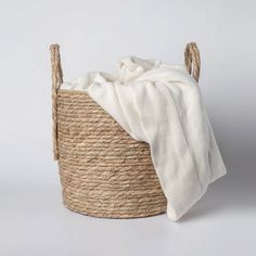 a white blanket sitting in a woven basket