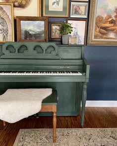 a green piano in front of pictures on the wall