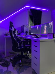 an office with purple lighting and two computer screens