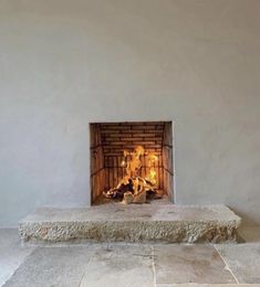 a fire place in the middle of a room with tile flooring and white walls