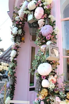 a pink building with flowers and pumpkins on it