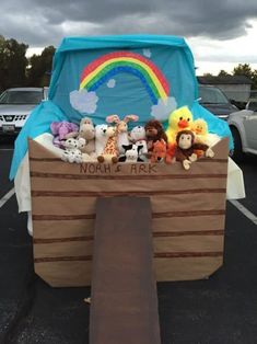 there is a boat with stuffed animals in it and a rainbow sign on the back