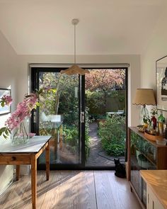 a living room with wooden floors and sliding glass doors that lead to a back yard