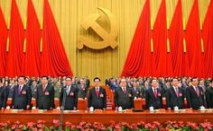 a large group of men in suits and ties standing on a stage with red curtains behind them