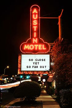 the neon sign is lit up for guests to take in their favorite movie show, austin motel