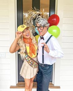 a man and woman dressed in costumes posing for the camera with balloons around their necks