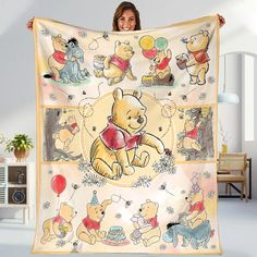 a woman holding up a blanket with winnie the pooh characters on it