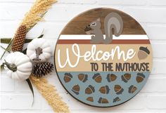 a welcome sign with a squirrel on it and the words welcome to the nuthouse