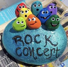 some rocks with faces painted on them and the words rock concert written in black ink