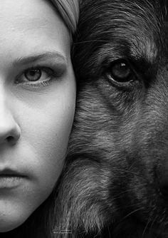 a black and white photo of a woman next to a large dog's face