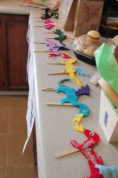 there are many colorful toothpicks lined up on the kitchen counter line with paper bags