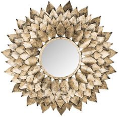 a mirror that is sitting on top of a wooden table and it has leaves in the shape of a sunburst