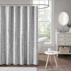 a bathroom with white and gray shower curtains