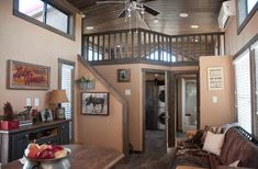 a living room filled with furniture and a ceiling fan