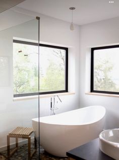 a large white bath tub sitting next to two windows