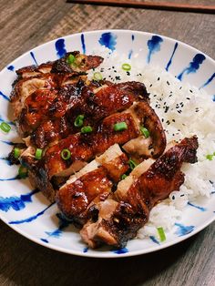 a white plate topped with meat and rice