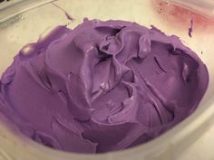 a bowl filled with purple frosting sitting on top of a counter