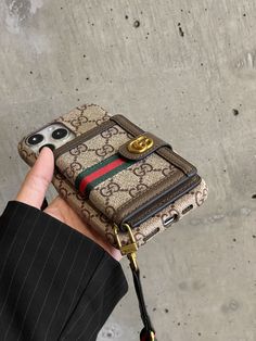 a person holding an iphone case in their hand with a gucci logo on it