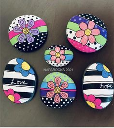 four painted rocks with flowers on them