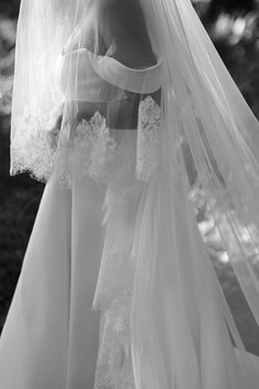 black and white photograph of a woman wearing a wedding dress with veil over her head