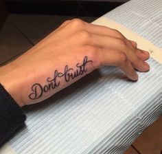 a person's hand with a tattoo that says don't trust