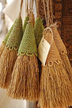 three straw bags hanging from a hook on a door handle with tags attached to them