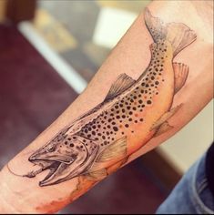 a man's arm with a tattoo of a fish and dots on the side