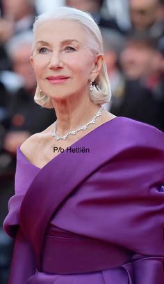 an older woman in a purple dress posing for the camera