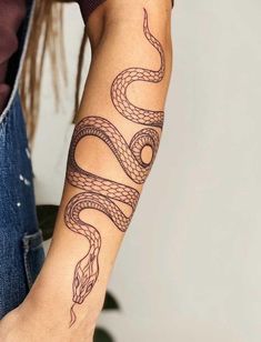 a woman's arm with a tattoo on it that has a snake on it