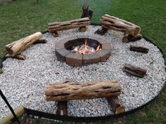 an outdoor fire pit with logs around it