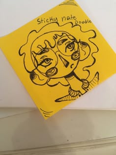 a piece of yellow paper with a drawing of a woman's face on it