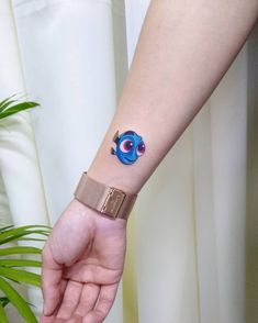 a person's arm with a tattoo on it and a small blue eyeball