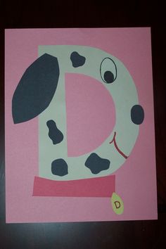 the letter d is made up of paper with a cow on it's face