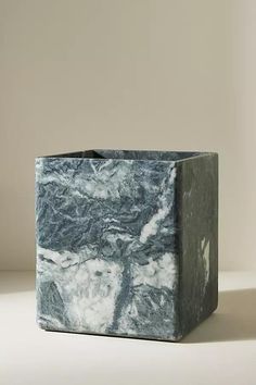 a marbled square vase sitting on top of a white table next to a wall