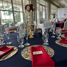 the table is set with place settings, silverware and red napkins