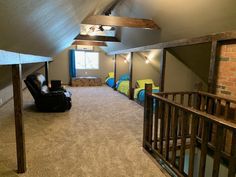 an attic bedroom with carpeted flooring and exposed ceilings