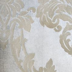 a white and beige wallpaper with an ornate design on it's back side