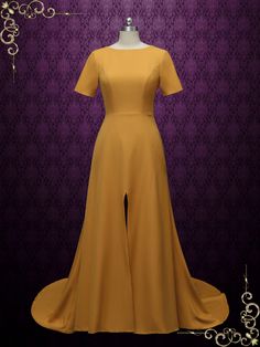 a dress is shown on a mannequin stand in front of a purple wall