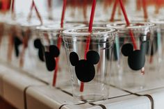 several cups with mickey mouse straws in them