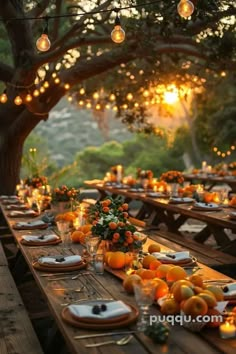 an outdoor dinner table set with oranges and candles