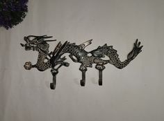 three metal dragon hooks hang on the wall