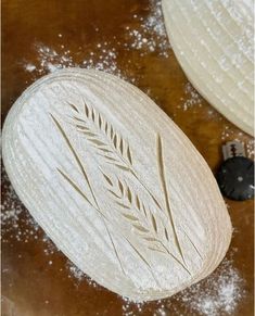 two white plates sitting on top of a wooden table covered in powdered sugar and sprinkles