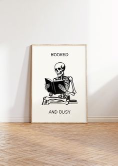 a skeleton reading a book with the words booked and busy on it in front of a white wall