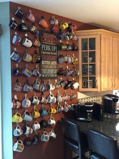 a kitchen wall with many cups hanging on it's side and a wooden cabinet in the background