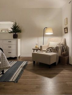 a living room filled with furniture and a lamp on top of a wooden floor next to a window