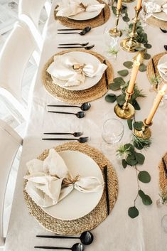 the table is set with white plates and place settings